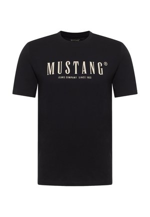Black short-sleeve t-shirt with "MUSTANG Jeans Company Since 1932" printed in large cream font on the front center.
