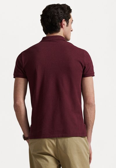 Polo shirt bordeaux à manches courtes, fabriqué en tissu respirant, avec un col classique et un design simple et ajusté.