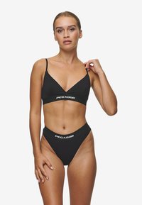 Black bikini set featuring a triangular bralette with adjustable straps and a logo band, paired with high-waisted, thong-style bottoms.