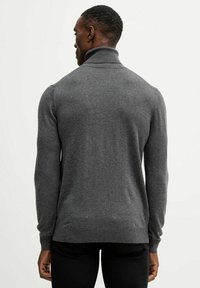 Maglione grigio a collo alto in maglia con design aderente, maniche lunghe e polsini a coste. Realizzato in tessuto morbido, caratterizzato da una texture uniforme.