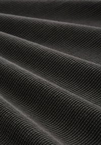 Strukturstoff in Dunkelgrau mit einem Rautenmuster aus erhöhten Fasern, die in sanften Wellen über die Oberfläche fließen.