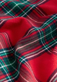 Rote Karostoff mit grünen und weißen diagonalen Linien, einem weichen, glatten Material und einem zerknitterten Aussehen aufgrund des Drapierens.