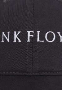 Black cap made of cotton with embroidered white "PINK FLOYD" text on the front. Features structured design and visible stitching details.