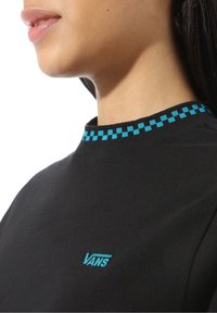 Black t-shirt featuring a blue checkerboard pattern on the collar, with a small blue Vans logo on the lower left side.