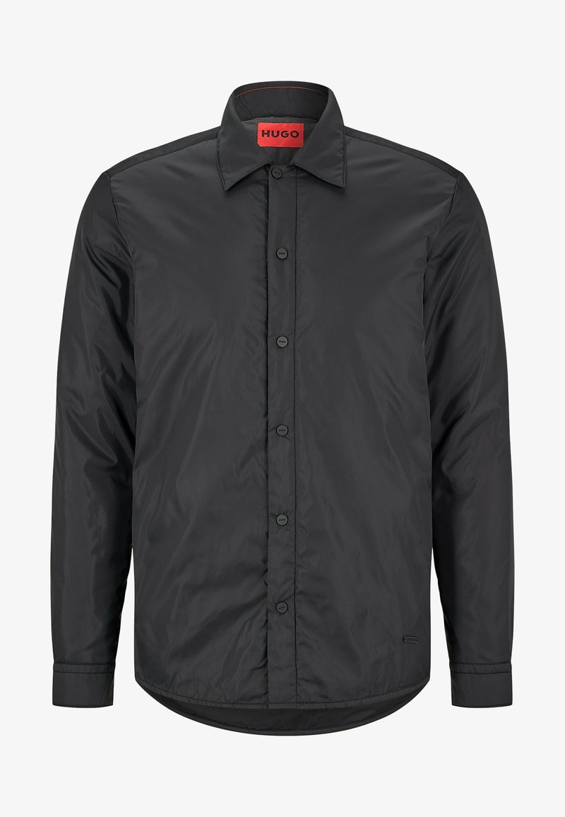 Veste noire à manches longues avec col, boutons à l'avant étiquetés "Hugo" et étiquette de marque rouge à l'intérieur du col.
