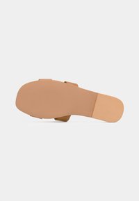 Tan sandaler med en glat tekstur, flad sål og to stroppåbninger. Har et simpelt, minimalistisk design uden yderligere udsmykninger.