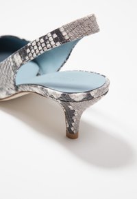 Scarpa con tacco slanciato con motivo in pelle di serpente grigia e nera, dotata di apertura sul retro e soletta azzurro chiaro. Superficie testurizzata, design elegante.