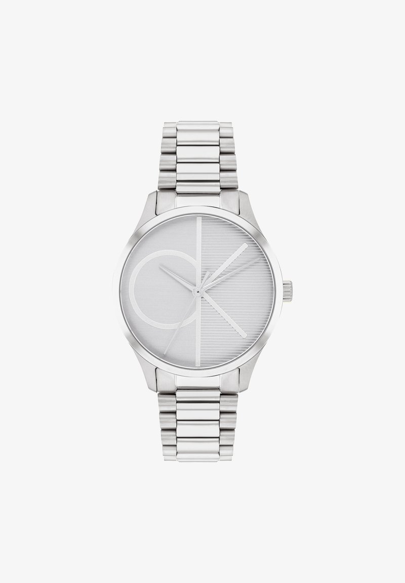 Reloj de acero inoxidable plateado con una esfera redonda, que presenta una esfera gris texturizada, un bold logo de CK y una pulsera de eslabones de metal.