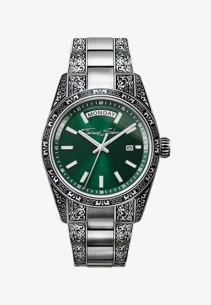Orologio da polso in argento con motivi incisi ornamentali, quadrante verde, visualizzazione di giorno e data, lancette luminose e logo Thomas Sabo sul quadrante.