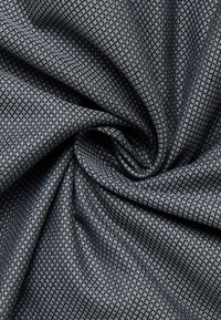 Struktureret stof i mørkegrå med et diamantmønster, blød overflade og en let glans, der hænger i folder for at afsløre sit design.