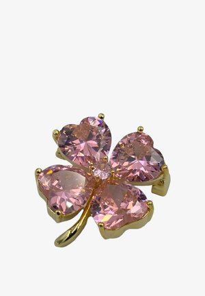 Spilla quadrifoglio con gemme rosa a forma di cuore e montatura in metallo color oro su sfondo bianco.