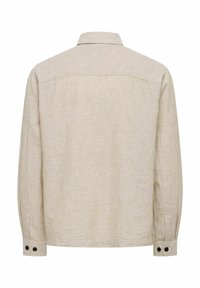 Beež pikkade varrukatega särk, millel on nööbitavad mansetid ja klassikaline krae, nähtav tagant valgel taustal.