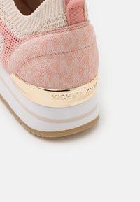 Rosa stickad sneaker med texturerade detaljer, utrustad med en guldfärgad logotypplatta och en skiktad sula med beige och vita ränder.