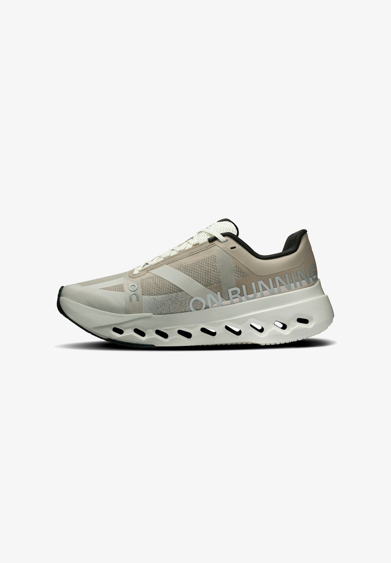 Light beige running shoe with a mesh upper, white accents, and a cushioned sole featuring cut-out details. "ON RUNNING" logo displayed.