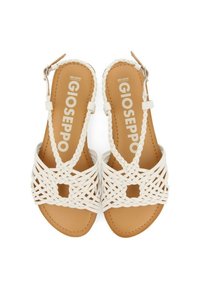 Sandalias blancas trenzadas con un diseño abierto, que cuentan con un corte central y una correa con hebilla. La plantilla es marrón, con el texto de la marca visible.