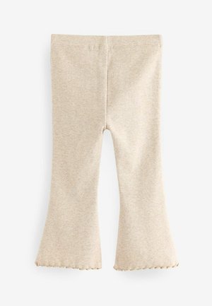 Jasnobeżowe dzwonowe legginsy o prążkowanej fakturze. Z falbaną na końcu, z dopasowanym pasem i gładkim wykończeniem.