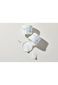 Vochtige Up Pad in een witte container, voorzien van ronde, gestructureerde waterschijven. Twee potten gestapeld op elkaar, met waterschijven gedeeltelijk zichtbaar.