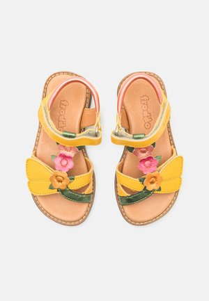 Gule lærsandaler har floral broderi i rosa og oransje, to framseler, en bakrem og en brun teksturert såle.