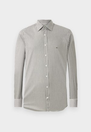 Pánska dlhá košeľa s dlhým rukávom s vertikálnymi tenkými čierno-bielymi pruhmi, s gombíkovou prednou časťou a špicatým golierom na jednoduchom pozadí.
