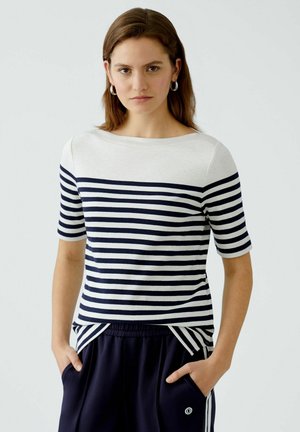 Striped short-sleeve top in white and navy, with a boat neckline and relaxed fit. Notable side slits and soft, breathable fabric.