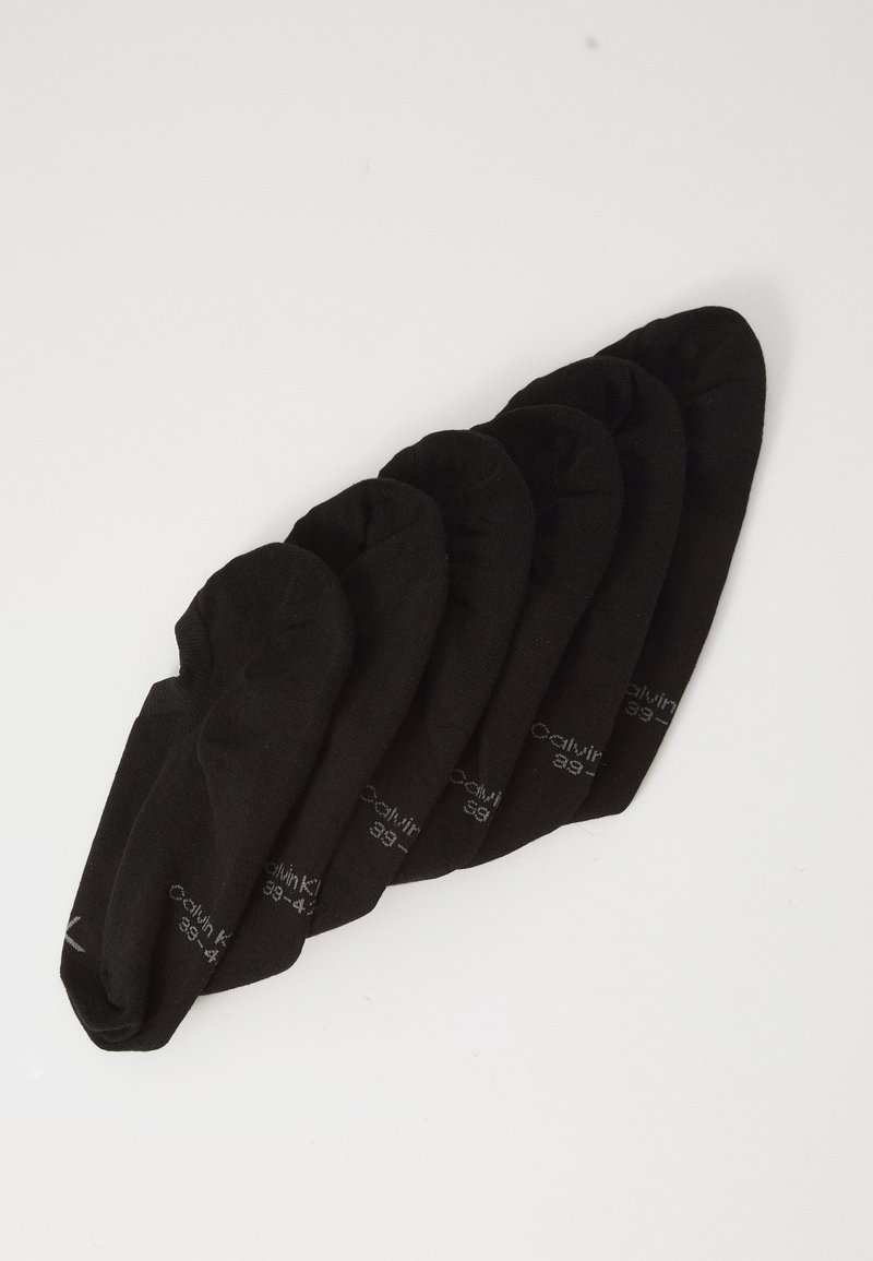 Sechs Paare schwarze, unsichtbare Socken mit kleinen weißen Texten, diagonal gestapelt auf einem weißen Hintergrund.