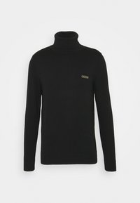 Pull en col roulé noir en maille lisse. Il possède des manches longues et un petit logo doré sur la zone gauche de la poitrine.