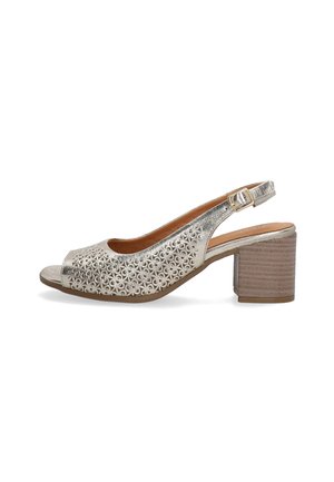 Metallic silver slingback shoe with an open toe, intricate cut-out pattern, and a textured block heel in a natural wood finish.