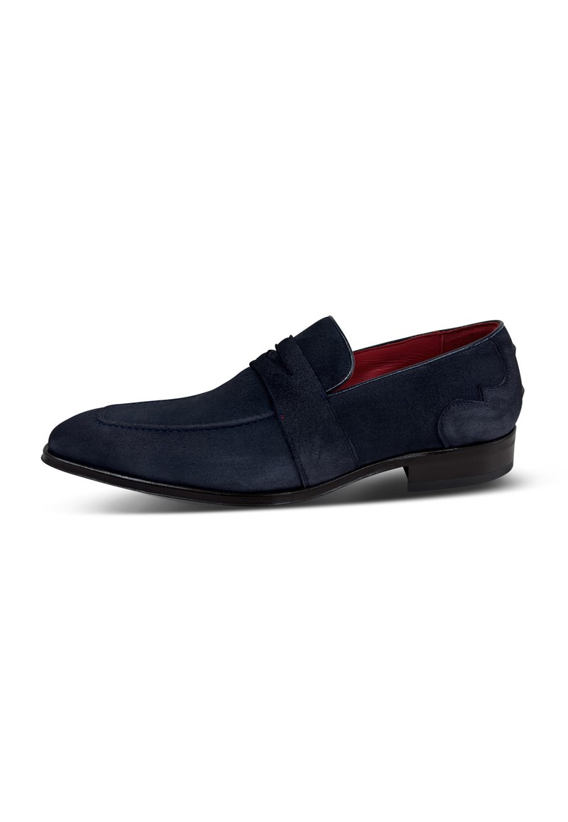 Mocasines de ante azul marino con una forma de punta definida, sutiles acentos decorativos y un revestimiento interior rojo en contraste. Suela plana de goma negra.