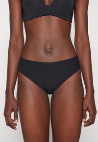 Svart ribbad bikiniunderdel med hög midja, med släta kanter och ett stretchbart tyg för komfort.