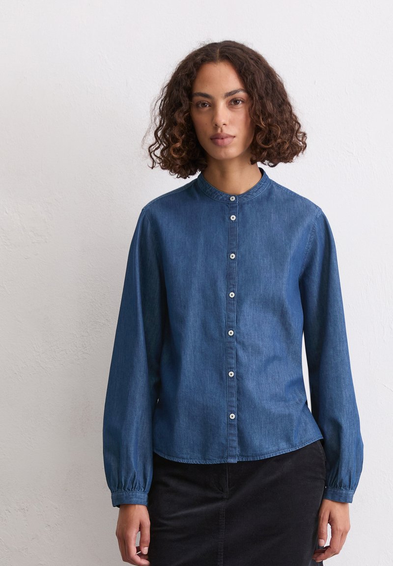Denim-Hemd, blau, mit rundem Kragen und langen Ärmeln. Verfügt über Frontknöpfe und Handgelenkabschlüsse mit gerafftem Design.