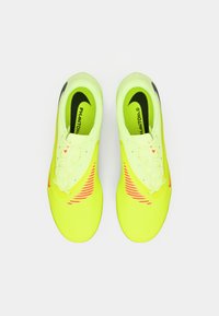 Jasnozielone buty piłkarskie z teksturowaną powierzchnią, różowymi akcentami i białymi sznurowadłami. Posiadają czarny znak „swoosh” i branding „Phantom”.