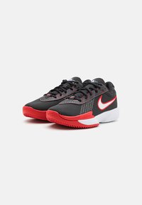 Et par sorte og røde Nike Zoom sneakers med hvide mellemsåler, røde ydersåler og hvide Nike swoosh-logoer på siderne.