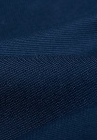 Marinfärgad tyg med en strukturerad väv, som har en jämn yta och ett subtilt mönster. Materialet verkar tjockt och hållbart.