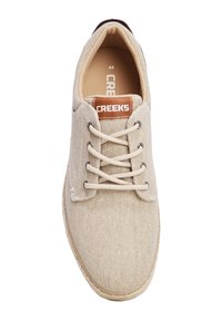 Scarpe beige in tela con lacci, dalla finitura testurizzata, caratterizzate da una toppa del logo marrone, lacci rotondi e una suola cucita di colore chiaro.