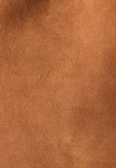 Κοντινή λήψη της υφής καφετέ μπούντε δέρματος σουέτ με εμφανείς λεπτές ίνες και φυσικές μεταβολές χρώματος.