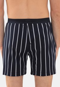Marineblauwe en witte gestreepte boxers met een elastische tailleband. De stof lijkt glad met een lichte textuur en een klassiek snitontwerp.