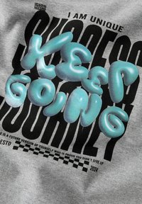 Tela gris con un diseño gráfico audaz. El texto incluye "SIGUE ADELANTE" en letras burbuja brillantes de color azul claro sobre un fondo negro con patrón.