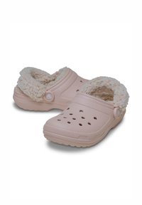 Roze klompen met een fluffy voering, geperforeerde zijkanten voor ventilatie, een gestructureerde rubbere zool en een knoopaccent op de bovenkant.