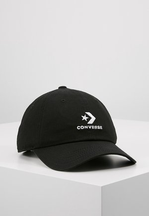 Casquette de baseball noire avec le logo Converse étoile-chevron blanc brodé sur le devant, présentée sur un socle blanc sur fond gris clair.