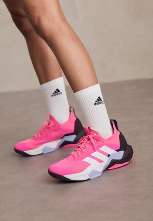 Roosad spordijalatsid valgete triipudega, millel on tekstuuriga pealisosa, paks must ja lillakas tallatald ning valged spordisokid musta logoga.
