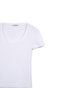 T-shirt bianco a maniche corte con scollo a barca, tessuto a coste texturizzato e forma aderente. Etichetta con la scritta "CALLIOPE."