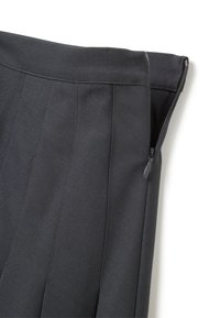 Pantaloni grigi a pieghe con una chiusura a cerniera visibile in vita, realizzati in un tessuto testurizzato che mette in mostra sottili dettagli di cucitura.