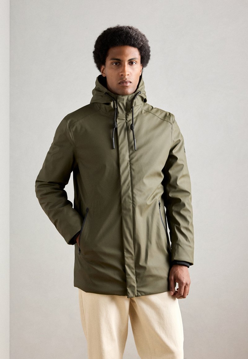 Oliven grøn vandtæt parka med en høj krave, justerbar hætte og lynlåslommer i siden. Glat tekstur og strømlinet design.
