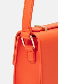 Borsa in pelle sintetica arancione brillante con chiusura e dettagli della tracolla in tono oro, caratterizzata da una texture liscia e linee pulite in una forma rettangolare.