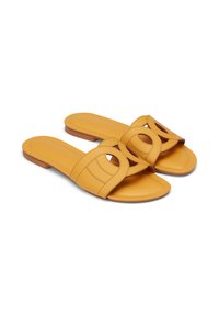 Yellow leather slide sandals with circular cutouts and a flat sole, showcasing a stylish and modern design.