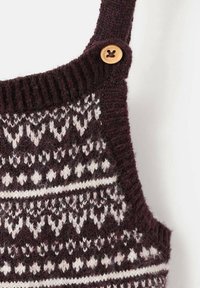 Pulover tricotat dintr-un material vișiniu, cu un model geometric alb, guler rib hașurat și detalii cu buton din lemn pe curea.