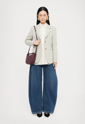 Lys grå blazer med gullknapper, hvit stripete skjorte, og brede blå jeans. Akkompagnert med en liten bordeaux-håndveske. Svart høye hæler.