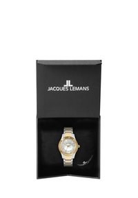 Orologio in oro e argento in una scatola nera, con bracciale a maglie metalliche, quadrante rotondo e quadrante bianco testurizzato con indicatori e lancette.