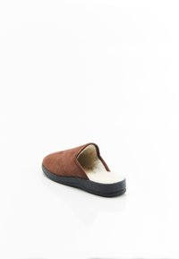 Bruine suede pantoffel met een zachte, beige nepbont voering en een zwarte rubberen zool. Open achterkant ontwerp met gestikte details op de bovenkant.