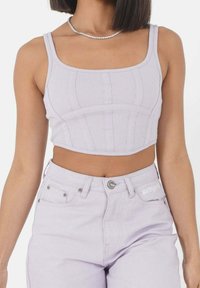Top de tanque recortado en lavanda clara con textura acanalada y escote cuadrado, combinado con unos jeans de talle alto a juego que cuentan con un acento de logo.